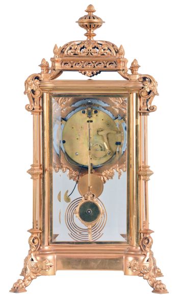 Ansonia Clock Co., New York, "Excelsior" crystal regulator, 8 day, time and strike, spring driven movement with visible Brocot escapement in a gilt finished brass case on claw feet, cream porcelain dial with Roman numerals and red interstitial decorations, cast pendulum with female face, strikes on cathedral gong.