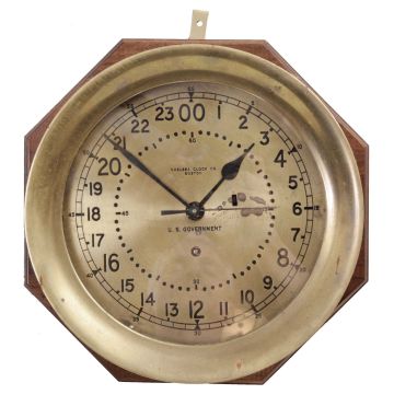 Chelsea Clock Co., Boston, Mass., "11E Deck & Engine Room" clock, 8 day, time only, spring-driven with jeweled movement, center seconds in a brass case with 8.5 inch dial showing 12/24 numerals, signed by Chelsea and "U.S. GOVERNMENT", all mounted to a mahogany backing board.