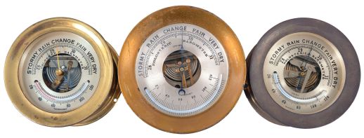 Barometers- 3 (Three) Marine Barometers: two signed by Chelsea Clock Co., Boston, Mass., holosteric barometers in brass cases with silvered dials and alcohol thermometers.