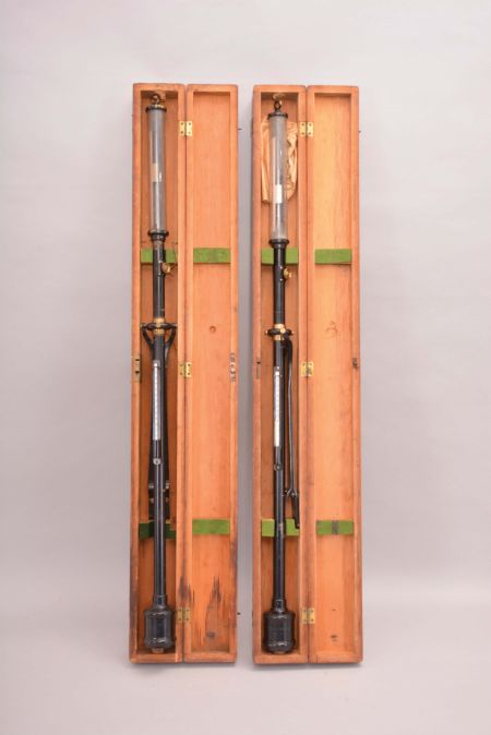 Barometers- 2 (Two) Henry J. Green, Brooklyn, New York, stick barometers, in black metal cases with brass hardware, silvered scales reading 26 to 33 with small vernier scale, thermometers on the outside of instruments, all in fitted finger-jointed wood cases with gimbaled mounts.