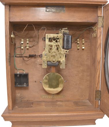 Self Winding Clock Company, New York, "No. 10-A Self Winding Clock", spring driven movement with deadbeat escapement and battery wind mechanism in an oak case with 14 inch aluminum dial reading "Official Time / Western Union ".