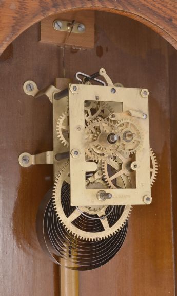 Ansonia Clock Co., New York, for Metropolitan Manufacturing Co., "Eclipse" hanging gingerbread clock, 8 day, time and simple calendar, spring driven movement in an oak case.