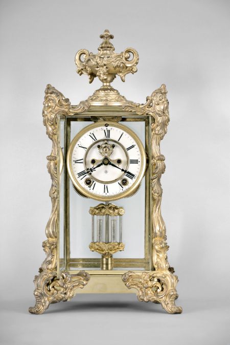 Ansonia Clock Co., New York, "Marchioness" crystal regulator with a spring driven 8 day time and half hour strike (rack and snail) movement (visible escapement) in a polished brass case with rich gold ornaments.