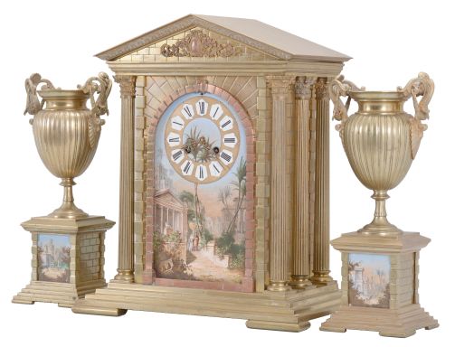 France, three piece mantel garniture set, 8 day, time and strike, spring driven pendule de Paris movement in a metal case of classic architectural form with stepped base, six full Corinthian columns flanking an ashlar facade with central arch, a painted ceramic panel within displaying a gilt chapter ring with Roman numerals, a scene of royals walking amidst an ancient city below the dial, all topped by a pediment with applied gilt ornament, two matching urns, both with painted ceramic panels.