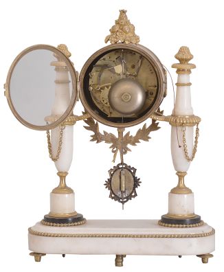 Courvoisier, a Paris, a late 18th century marble and gilt bronze mantel clock, the oblong base on toupie feet with inset, reeded mounts and central foliate ornament, and finished with a gilt bead molding, the gilt clock case with laurel and bowknot drop, and surmounted by a pyramid of fruit, the case supported bu two slender vasiform columns, with foliate and basket weave mounts, and gadrooned rings, arabic numeral white enamel dial, signed "Courvoisier a Paris", well executed pierced and engraved gilt hands, 8 day two train movement with crown wheel escapement, the Swiss style strike work mounted to the back plate, and with silk thread suspension, repeating the last hour on demand