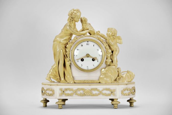 Samuel Marti, Paris, France, figural mantel clock, 8 day, time and strike, spring driven pendule de Paris movement in a white marble case on turned brass feet with applied gilt ornaments, supporting gilt figures of a woman, dog, and Cupid, white convex enamel dial with Arabic numerals and gilt fleur-de-lis hands.