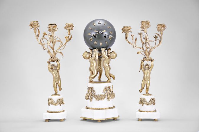 Japy Freres, Paris, France, three piece mantel garniture set, 8 day, time and strike, spring driven movement with platform escapement, the case with three putti supporting a sphere with applied roman numerals and arrow hands resting on a marble base with gilt cast appliques and two matching side pieces with putti holding aloft the candleabra