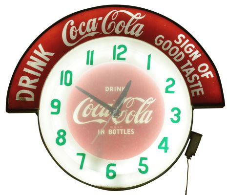 Clocks- 2 (Two) Coca Cola electric backlit advertising clocks: (1) Large period sign advertising "DRINK Coca Cola SIGN OF GOOD TASTE" with 24.5" plastic dial reading "DRINK IN BOTTLES "; (2) Small reproduction in 50