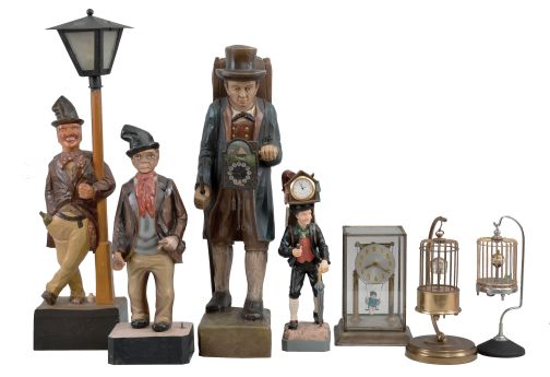 Novelties- 7 (Seven): lot includes: carved figure leaning on a lamp post which holds a small incandescent bulb; plastic battery-operated whistler figure; small clock peddler figure with quartz watch movement; large cast clock peddler figure with German novelty clock movement; Japanese swinging doll clock under glass; German made birdcage clock; Japanese made birdcage clock.