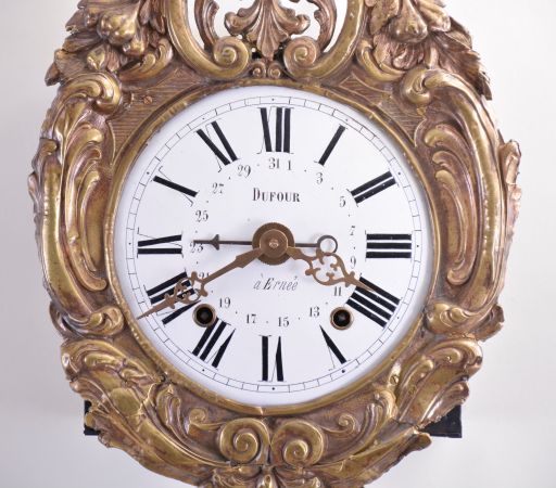 France, Morbier or Comtoise clock, 8 day, time and strike with simple calendar, weight driven movement with anchor escapement in an iron post and plate frame, convex white enamel dial with Roman numerals signed "Dufour à Erneé", press brass fronton and matching pendulum with scroll design, two pierced brass hands an one iron hand.