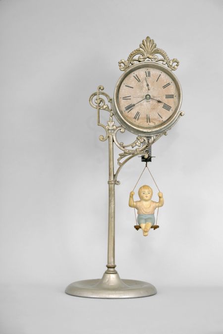 Ansonia Clock Co., New York, "Jumper No. 1" bobbing doll shelf clock with a spring driven one day timepiece movement in a nickel plated case.