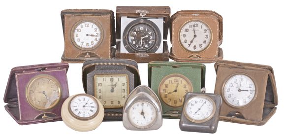 Desk and travel clocks- 10 (Ten), 30 hour and 8 day, Swiss and American, makers including Waltham, New Haven, Majestic, Junghans, and others, most with folding, leather bound cases, one desk clock with molded celluloid case and white enamel dial advertising the Lady Racine watch, another with gunmetal case and easel back, and more