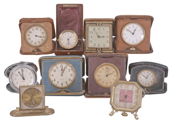 Desk and travel clocks- 10 (Ten), 30 hour and 8 day, Swiss and American, makers including Waltham, New Haven, Waterbury, Keinzle, Normis, and others, most with folding, leather bound cases, one desk clock with octagonal case, easel back, and pink mother of toilet seat center, an unusual Waterbury travel clock with wooden case, and more