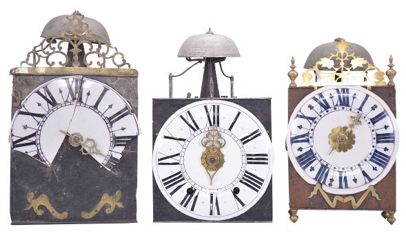 Clocks- 3 (Three) Comtoise wall clocks: (1) France, Comtoise clock, 8 day, time and strike, weight driven movement with verge escapement, thread suspension with rear-hanging pendulum in an iron post and plate frame, 9 inch faïence dial with large Roman numerals, single brass hand, flat pierced brass fronton, two pivoted brass winding arbor shutters, mid 18th Century. (2) France, Comtoise wall clock, 8 day, time and strike with alarm, weight driven movement with verge escapement, thread suspension with rear-hanging pendulum in an iron post and plate frame, 8.5 inch enamel dial with flat center and convex chapter, large Roman numerals, and single brass hand, mid 18th Century. (3) France, Comtoise "lantern" clock, 8 day, time and strike, weight driven movement with verge escapement, thread suspension with rear-hanging pendulum outside the plate in an iron post and plate frame, 7.75 inch faïence dial with large Roman numerals in dark blue, single brass hand, resting on turned brass feet, topped by flat brass fronton flanked by two turned brass finials, two pivoted brass winding arbor covers, mid 18th Century.