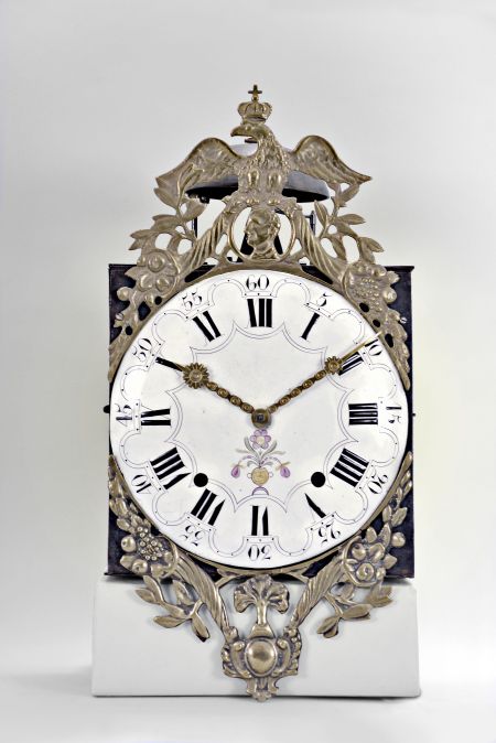 France, Comtoise wall clock, 8 day, time and strike, weight driven movement with verge escapement, thread suspension with front-hanging pendulum in an iron post and plate case with white enamel convex Roman numeral arcaded dial with Arabic minutes, polychrome floral decoration above the 6 o