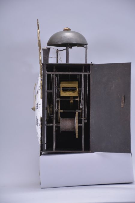 France, Comtoise wall clock, 8 day, time and strike, weight driven movement with verge escapement, thread suspension with front-hanging pendulum in an iron post and plate case with white enamel convex Roman numeral arcaded dial with Arabic minutes, polychrome floral decoration above the 6 o