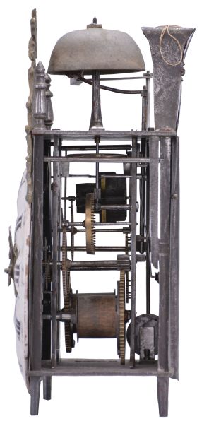 France, Comtoise lantern clock, 8 day, time and strike with alarm, weight driven movement with verge escapement, thread suspension with rear-hanging pendulum in an iron post and plate frame, early faïence dial with raised portions under each Roman numeral, outer ring with Arabic numerals every five minutes, two steel hands, brass alarm ring with Arabic numerals, topped by a cast brass fronton with image of the sun / Apollo flanked by two turned iron finials, all standing on tapered iron feet.