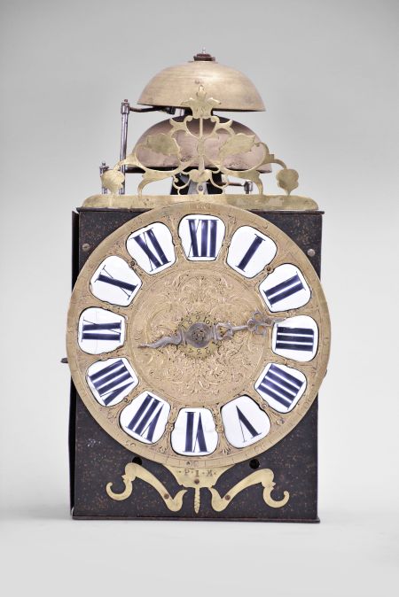 France, Comtoise clock, 8 day, time and strike with alarm, weight driven movement with verge escapement, thread suspension with rear-hanging pendulum in an iron post and plate frame, cast brass dial signed "P I M" with inset white enamel cartouches with blue Roman numerals, alarm ring with Arabic numerals, single iron hand, topped by a pierced brass fronton.