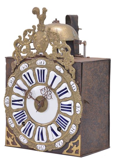 France, bronze-front Comtoise clock, 8 day, time and strike with alarm, weight driven movement, verge escapement with thread suspension and rear-hanging pendulum in an iron post and plate frame, cast brass dial with inset white enamel cartouches with blue Roman numerals for the hours and black Arabic numerals for the minutes, brass alarm ring with Arabic numerals, two pierced steel hands, applied brass spandrels below the dial, and topped with a cast fronton featuring a forward facing Gallic rooster over a medallion with three fleur de lis.