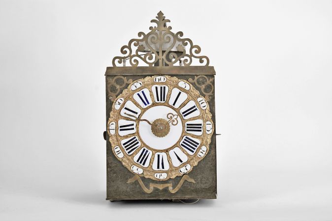 France, month-running Comtoise clock, 30 day, time and strike with alarm, weight driven movement, verge escapement with thread suspension and rear-hanging pendulum in an iron post and plate frame, cast brass dial with inset white enamel cartouche numerals with blue Roman numerals, outer ring with Arabic numerals every five minutes, brass alarm ring with Arabic numerals, two brass hands, applied brass spandrels and pivoted winding arbor shutters, all topped by a pierced brass fronton.