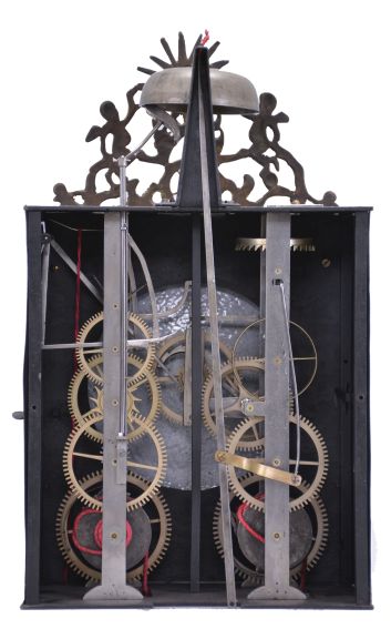 France, month-running Comtoise clock, 30 day, time and strike, weight driven movement, verge escapement with thread suspension and rear-hanging pendulum in an iron post and plate frame, white enamel dial with concave center and convex chapter, Roman numerals for the hours and Arabic numerals every five minutes, two pierced iron hands, pivoted brass winding arbor shutters below the dial, all topped by a cast fronton featuring the sun flanked by putti and displaying the star symbol used during the French Restoration Period.