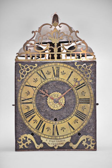 F. Farjaire, Saint-Étienne, France, three train Comtoise clock, 8 day, time and quarter strike with alarm, three bells, weight driven movement with verge escapement, thread suspension with rear-hanging pendulum in an iron post and plate frame, brass chapter with Roman numerals, Arabic numerals at 5 minute intervals on the outer rim, brass alarm ring with Arabic numerals, two iron hands, pivoted brass winding arbor shutters, engraved plaque with the maker