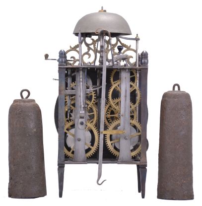 France, Comtoise lantern clock, 8 day, time and strike with alarm, weight driven movement with Chevalier de Béthune escapement, thread suspension with rear-hanging pendulum in a iron posted iron frame, brass chapter ring with engraved Roman numerals, brass alarm ring with engraved Arabic numerals, two iron hands, all surmounted by a cast brass fronton and four turned iron finials.