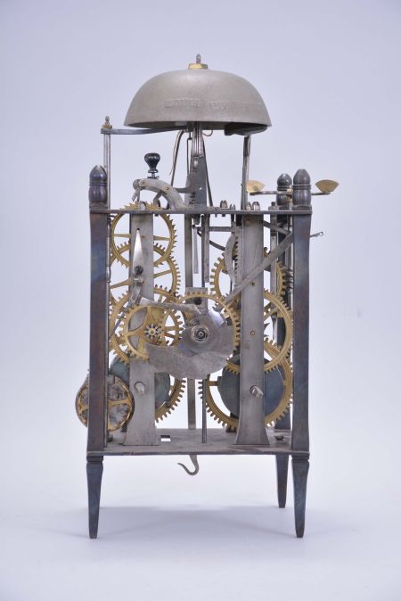 France, Comtoise lantern clock, 8 day, time and strike with alarm, weight driven movement with Chevalier de Béthune escapement, thread suspension with rear-hanging pendulum in a iron posted iron frame, brass chapter ring with engraved Roman numerals, brass alarm ring with engraved Arabic numerals, two iron hands, all surmounted by a cast brass fronton and four turned iron finials.