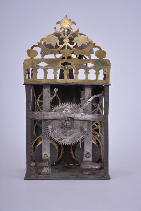 Blondeau, Châtelblanc, France, Comtoise clock, 8 day, time and strike, weight driven movement with Chevalier de Béthune escapement variant, thread suspension with rear-hanging pendulum in a iron post and plate frame, brass chapter ring with engraved Roman numerals, brass alarm ring with Arabic numerals, pivoted winding arbor shutters engraved with "Blondeau / 1734 / Chatel Blanc", single pierced brass hand, the top sides and front with one piece arcaded gallery with integrated pierced and engraved brass fronton.