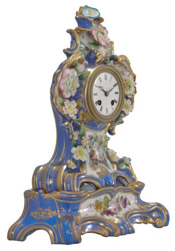 France, two-part porcelain mantel clock, 8 day, time and strike, pendule de Paris movement with silk thread suspension, the case in the style of Jacob Petit, decorated with molded and brightly painted naturalistic ornament, blue ground highlighted by bright gilding, white enamel dial with Roman numerals, Breguet style steel hands, all resting on a wood base under a glass dome