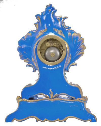 France, two-part porcelain mantel clock, 8 day, time and strike, pendule de Paris movement with silk thread suspension, the case in the style of Jacob Petit, decorated with molded and brightly painted naturalistic ornament, blue ground highlighted by bright gilding, white enamel dial with Roman numerals, Breguet style steel hands, all resting on a wood base under a glass dome